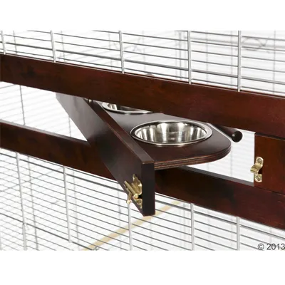 Дървена вратичка с метални панти на клетка, вградени две метални купички за храна или вода. Видими са решетки от метал и заключващ механизъм.