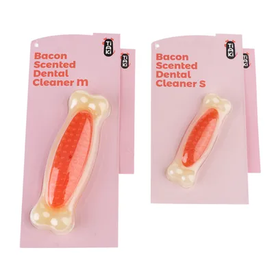 Tiaki Bacon Scented Dental Cleaner u veličinama M i S, dizajn u obliku kosti s crvenim središnjim dijelom na ružičastom pakiranju.