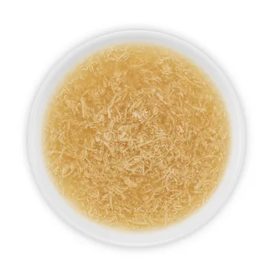 Nourriture humide pour animaux dans une assiette blanche, aspect effiloché et en sauce, sans marque visible ni texte.