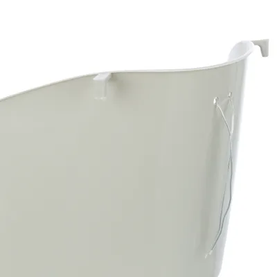 Close-up view of a white plastic container with hook and wire attachment on the side.