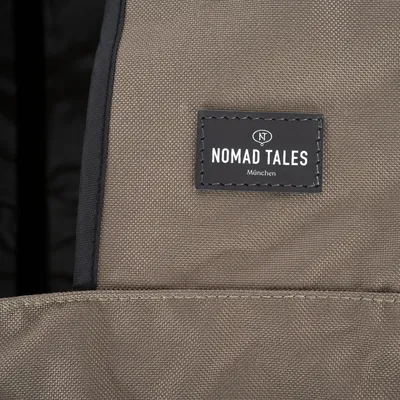 Nomad Tales München logo op bruine stof.