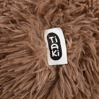 Nahaufnahme des Tiaki-Logos auf einem braunen, flauschigen Material.