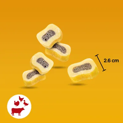 Przekąska z żółtą otoczką i ciemnym nadzieniem, długość 2,6 cm. Symbol wołowiny, kurczaka, kaczki i indyka w lewym dolnym rogu.