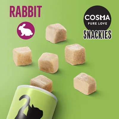 COSMA PURE LOVE SNACKIES, RABBIT, zobrazené kostky pamlsků a část obalu s černou siluetou kočky