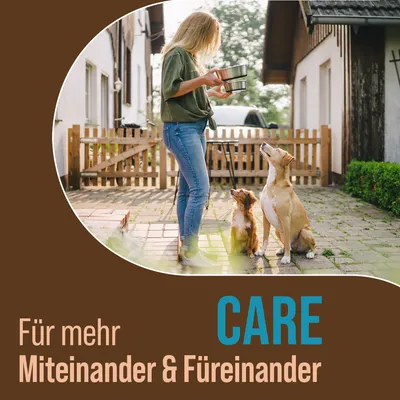 CARE Für mehr Miteinander & Füreinander (texte en allemand) avec une femme tenant des gamelles devant deux chiens assis dans une cour pavée.