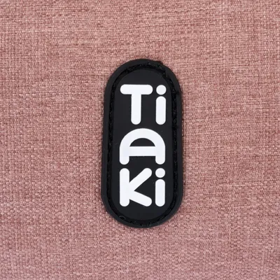 Tiaki. Markenlogo auf rosa Stoffhintergrund.