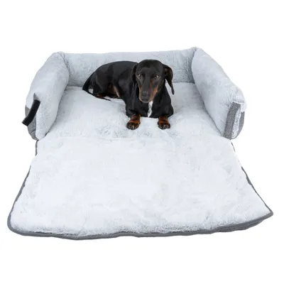 Hund liegt auf grauem, gepolstertem Hundebett mit ausklappbarer Liegefläche und erhöhten Seitenrändern.