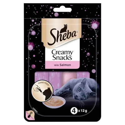 Sheba Creamy Snacks with Salmon, 4 x 12g. Visible text: Hand Feed. Image shows a grey cat and a bowl of creamy snack on the packaging.