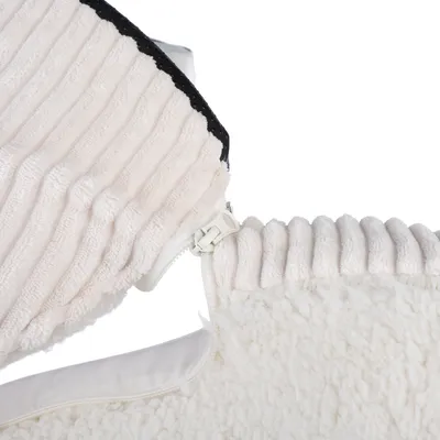 Gros plan sur une housse en tissu côtelé beige avec fermeture éclair blanche, doublure intérieure blanche et surface en tissu imitation laine.