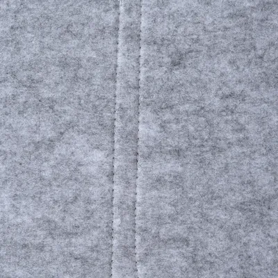 Close-up of grey felt material with visible seam in the centre.