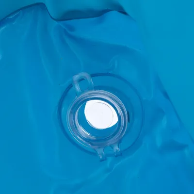 Närbild av en transparent ventil på en blå yta, eventuellt del av en uppblåsbar produkt.