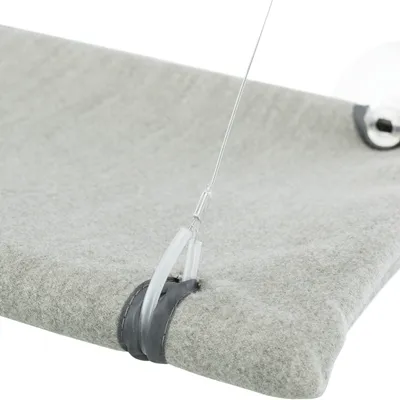 Détail d’un support en tissu gris fixé par un câble métallique et une ventouse transparente, sans marque visible.