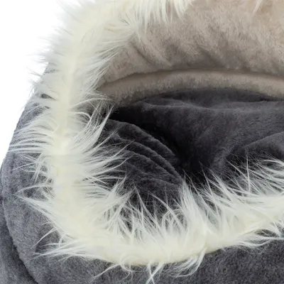 Närbild av en grå, fluffig husdjursbädd med vit konstpälsrand och mjuk innervaddering.