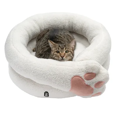 Cat bed made of white plush with pink paw motif, cat lying inside. Visible logo: Trixie.