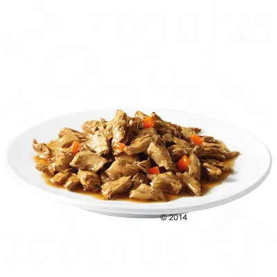 Парченца месо в сос с малки парчета моркови, сервирани в бяла чиния. Без видима марка или опаковка.