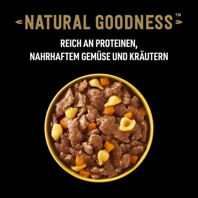 Natural Goodness. Reich an Proteinen, nahrhaftem Gemüse und Kräutern. Schüssel mit Fleischstücken, Gemüse und Kräutern in Sosse.