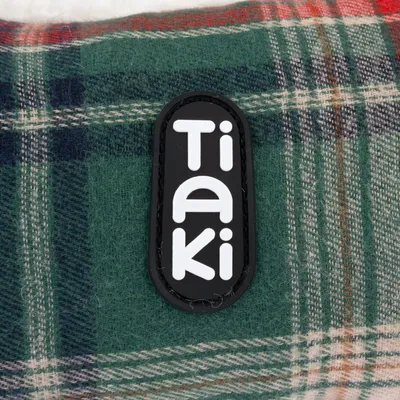 Tiaki-Logo auf grün kariertem Stoff.