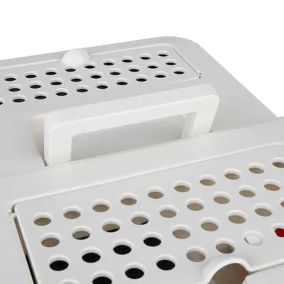 Bílý transportní box s ventilačními otvory a držadlem, vhodný pro domácí mazlíčky.