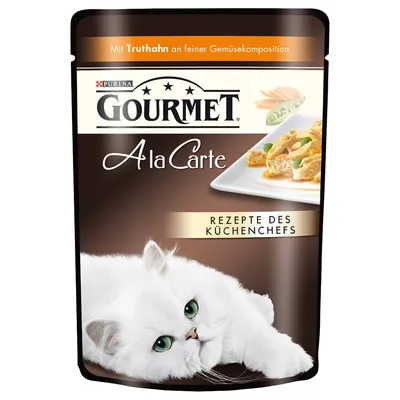Purina Gourmet A la Carte, Mit Truthahn an feiner Gemüsekomposition, Rezepte des Küchenchefs. Opakowanie z białym kotem i zdjęciem dania na talerzu.