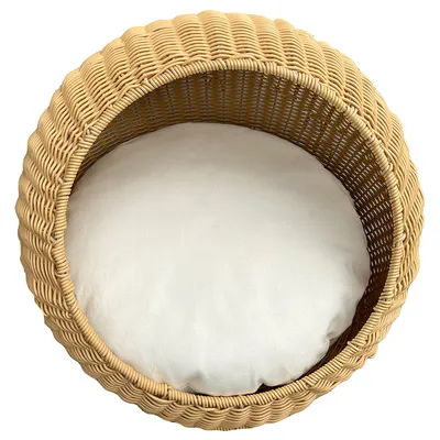 Rundes Körbchen aus geflochtenem Rattan mit weissem Kissen, geeignet als Schlafplatz oder Ruhebereich.