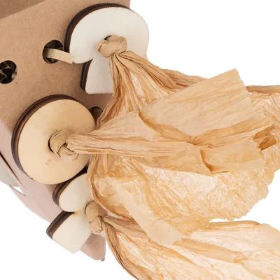 Jouet pour animal en bois et carton, avec lanières de papier kraft nouées, éléments ronds en bois fixés sur une structure à trous.