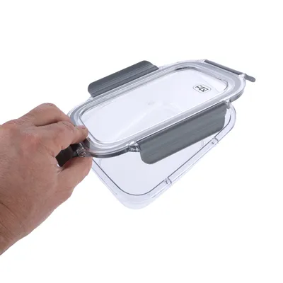 Transparente kunststofbox met grijze sluitingen, geopend en vastgehouden door een hand.