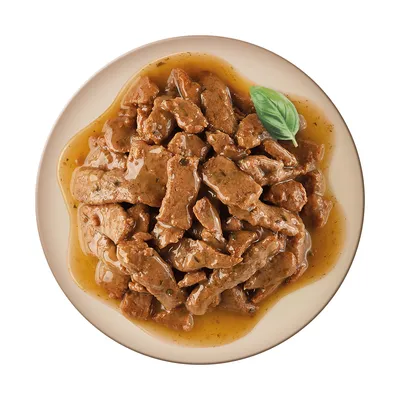Close-up of meat pieces in sauce, served on a plate with a basil leaf as garnish.