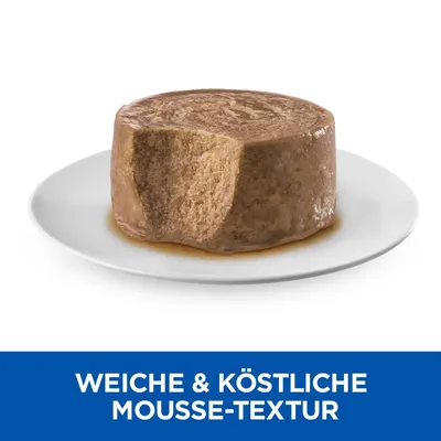 Mokra hrana za hišne ljubljenčke v obliki rjavega moussa na belem krožniku. Besedilo v nemščini: WEICHE & KÖSTLICHE MOUSSE-TEXTUR.