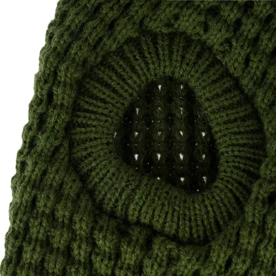 Gros plan sur une ouverture ronde dans un tissu tricoté vert foncé, matière laine visible.