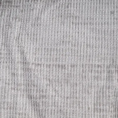 Gros plan sur une surface en tissu gris à texture côtelée, matière textile visible.