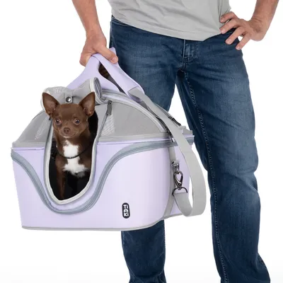 Sac de transport Trixie lavande avec poignée et bandoulière, chien assis à l’intérieur, parties en maille visibles pour aération.