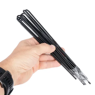 Hand hält mehrere schwarze Metallstäbe, die an einem Ende mit Kunststoff umwickelt sind.