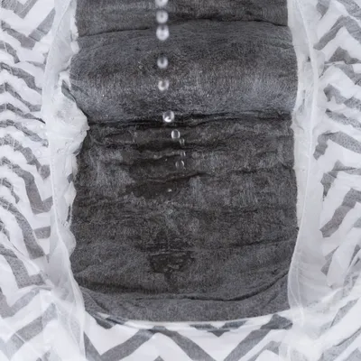 Nahaufnahme einer absorbierenden Schicht mit Tropfen Wasser, die auf die Oberfläche fallen. Zeigt die Flüssigkeitsaufnahme des Materials.