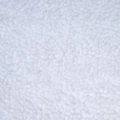Gros plan sur une surface en tissu polaire blanc, texture bouclée visible.