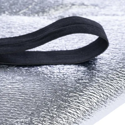 Silverfärgad, reflekterande yta med svart elastiskt band. Materialstruktur synlig.