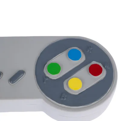 Igračka u obliku sivog kontrolera s raznobojnim tipkama: zelena, plava, žuta i crvena, označene s X, Y, A i B.