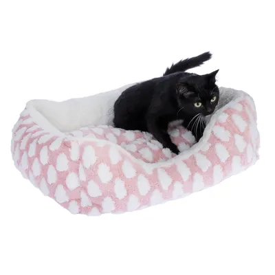 Schwarze Katze sitzt in einem rosa-weissen, gepunkteten Haustierbett mit weicher Polsterung.