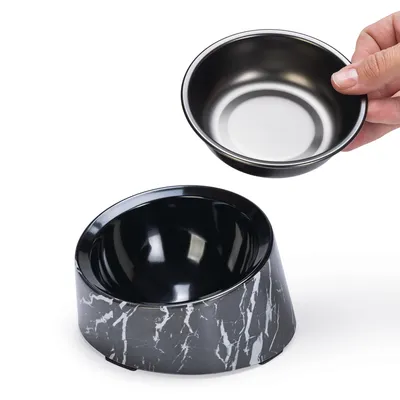 Schwarzer Futternapf mit herausnehmbarer Edelstahlschale, Marmordesign auf der Basis. Hand zeigt die abnehmbare Schale.