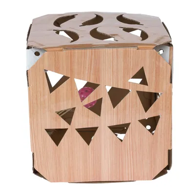 Cardboard cube with wood look and cut-out triangles, visible pink toy inside.