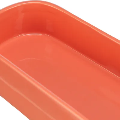 Červená keramická miska se zaoblenými rohy, vhodná na krmivo nebo vodu.