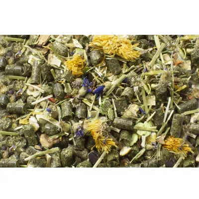 Nahaufnahme von getrocknetem Kleintierfutter mit Pellets, Heu, Blüten und Kräutern.