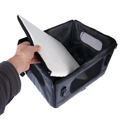 Transportbox z odpinanym, wyściełanym dnem i oknami z siatki. Ręka pokazuje otwarcie dna.