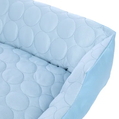 Jasnoniebieski, pikowany materiał z okrągłym wzorem, odpowiedni na legowiska lub poduszki dla zwierząt.