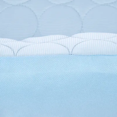 Zbliżenie niebieskiego materiału tekstylnego z pikowanym wzorem i gładką powierzchnią.