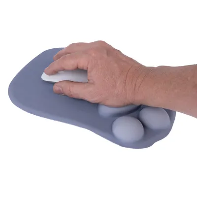 Main utilisant une souris d’ordinateur sur un tapis de souris gris en forme de patte avec repose-poignet intégré, surface lisse et coussinets visibles.