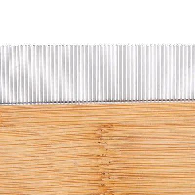 Peigne avec dents métalliques et manche en bois, vue rapprochée sur les dents alignées verticalement et la texture du bois visible.