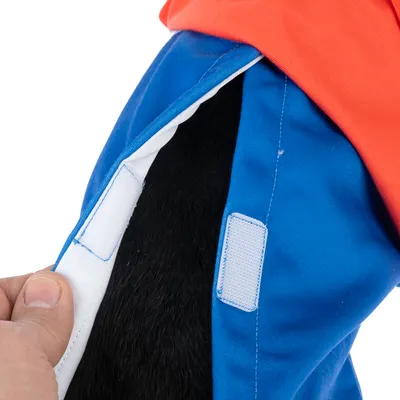 Primo piano di un indumento blu e arancione con chiusura in velcro aperta che mostra una zona di pelo nero.