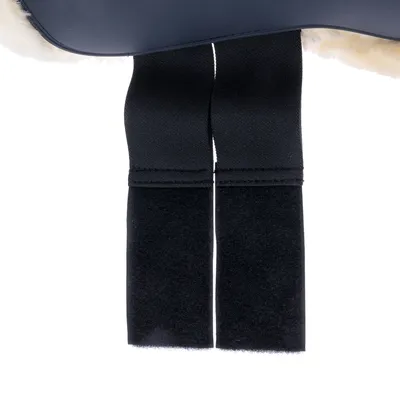 Gros plan sur deux bandes velcro noires cousues à un matériau doublé de fausse fourrure blanche, parties visibles en tissu et velours.