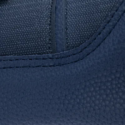 Gros plan sur une surface en similicuir bleu avec couture visible et tissu textile bleu, montrant les matériaux du produit.