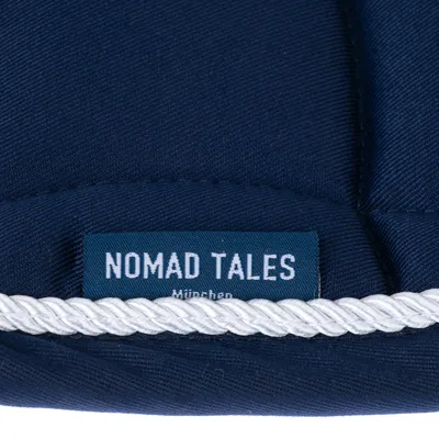 Nomad Tales München. Label auf dunkelblauem Stoff mit weisser Kordel.